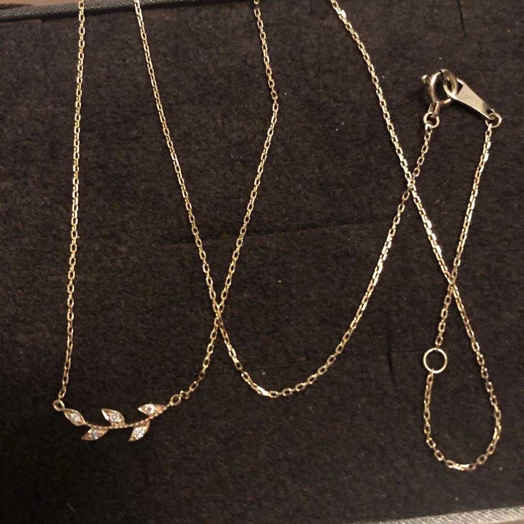 Close-up of agate Laurel Leaf K10 necklace featuring small diamonds on a shiny gold chain
