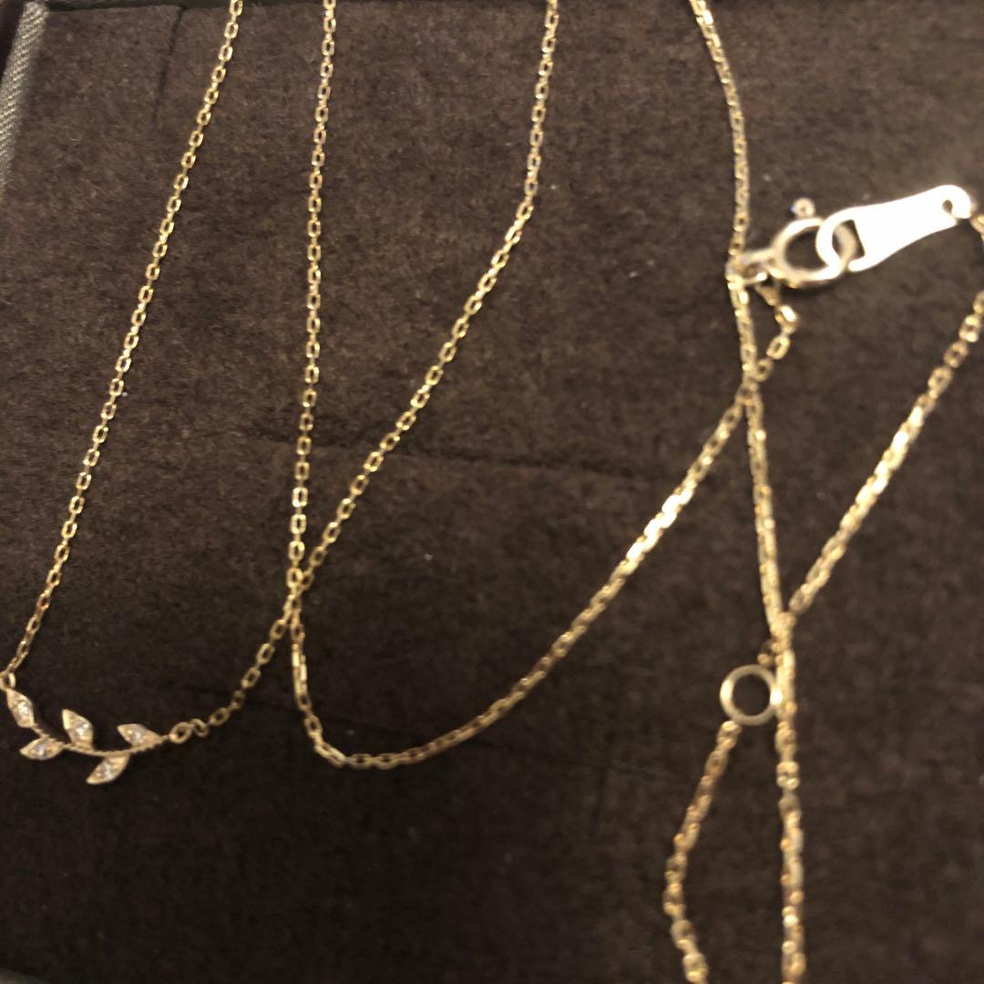 Close-up of agate Laurel Leaf K10 necklace featuring small diamonds on a shiny gold chain
