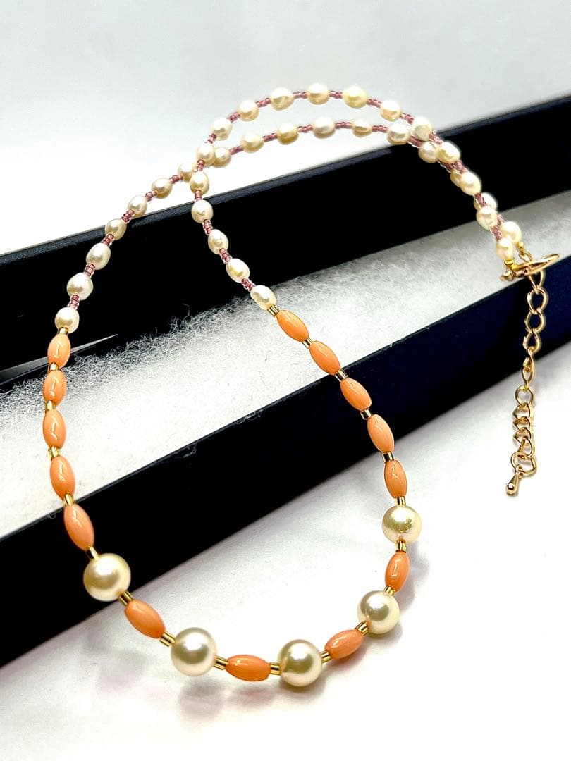 Akoya pearl and pink coral genuine pearl gold necklace with adjustable length and varying bead sizes