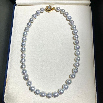 Akoya pearl necklace featuring large 9.0mm round pearls with gold hardware and flower-shaped clasp in blue-gray tone