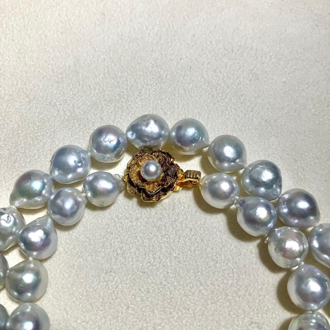 Akoya pearl necklace featuring large 9.0mm round pearls with gold hardware and flower-shaped clasp in blue-gray tone