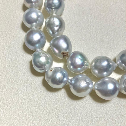 Akoya pearl necklace featuring large 9.0mm round pearls with gold hardware and flower-shaped clasp in blue-gray tone