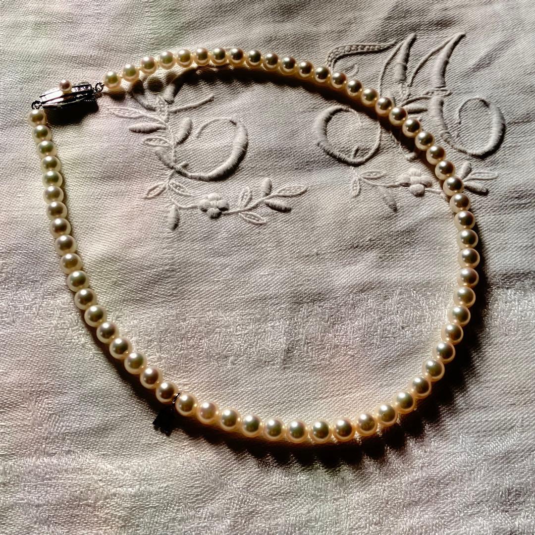 MIKIMOTO pearl choker necklace with 63 round pearls and silver M engraved clasp displayed with original box
