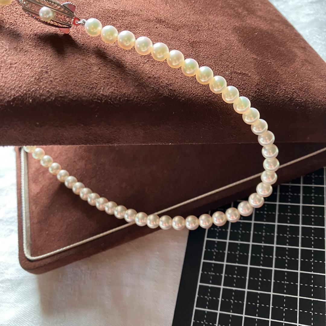 MIKIMOTO pearl choker necklace with 63 round pearls and silver M engraved clasp displayed with original box