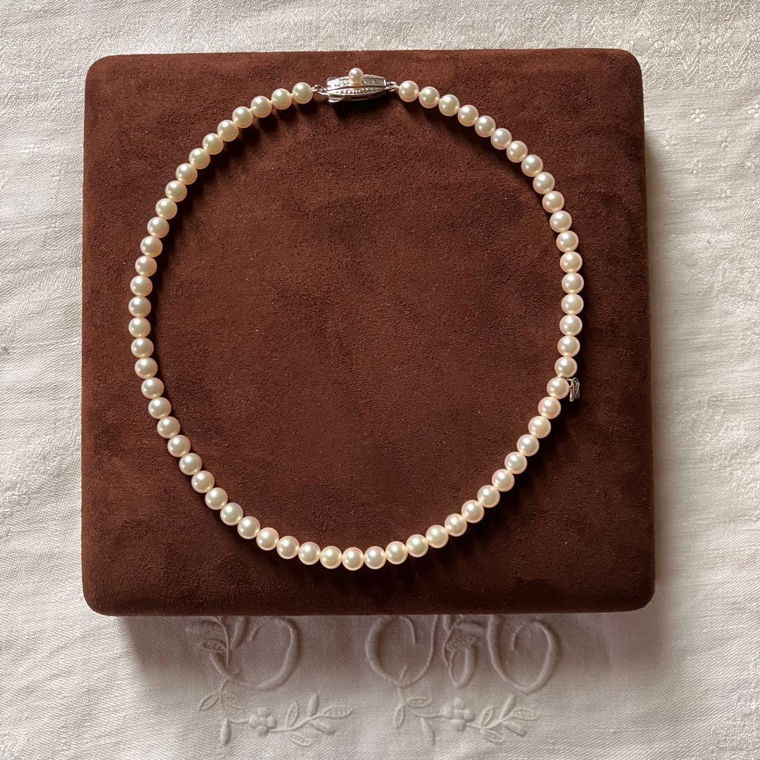 MIKIMOTO pearl choker necklace with 63 round pearls and silver M engraved clasp displayed with original box