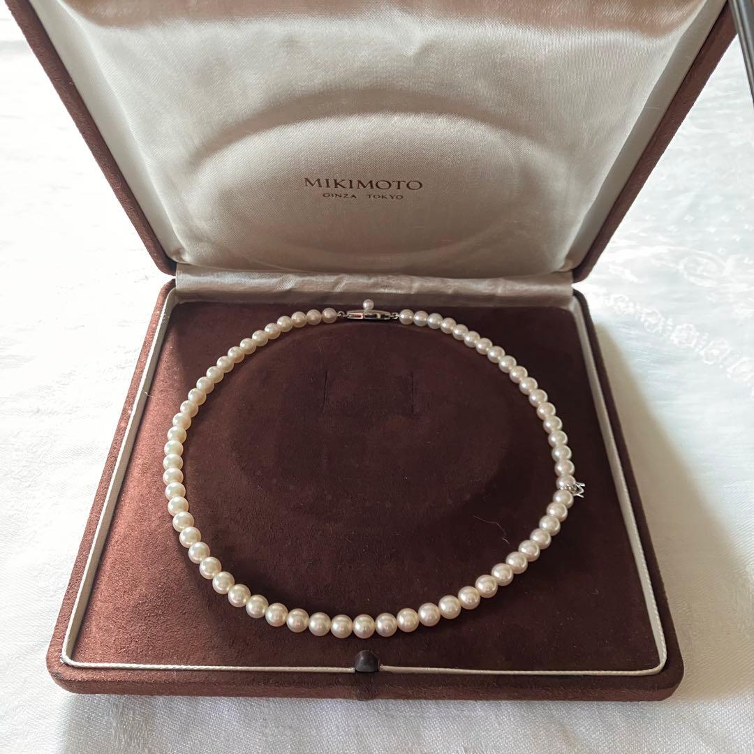 MIKIMOTO pearl choker necklace with 63 round pearls and silver M engraved clasp displayed with original box
