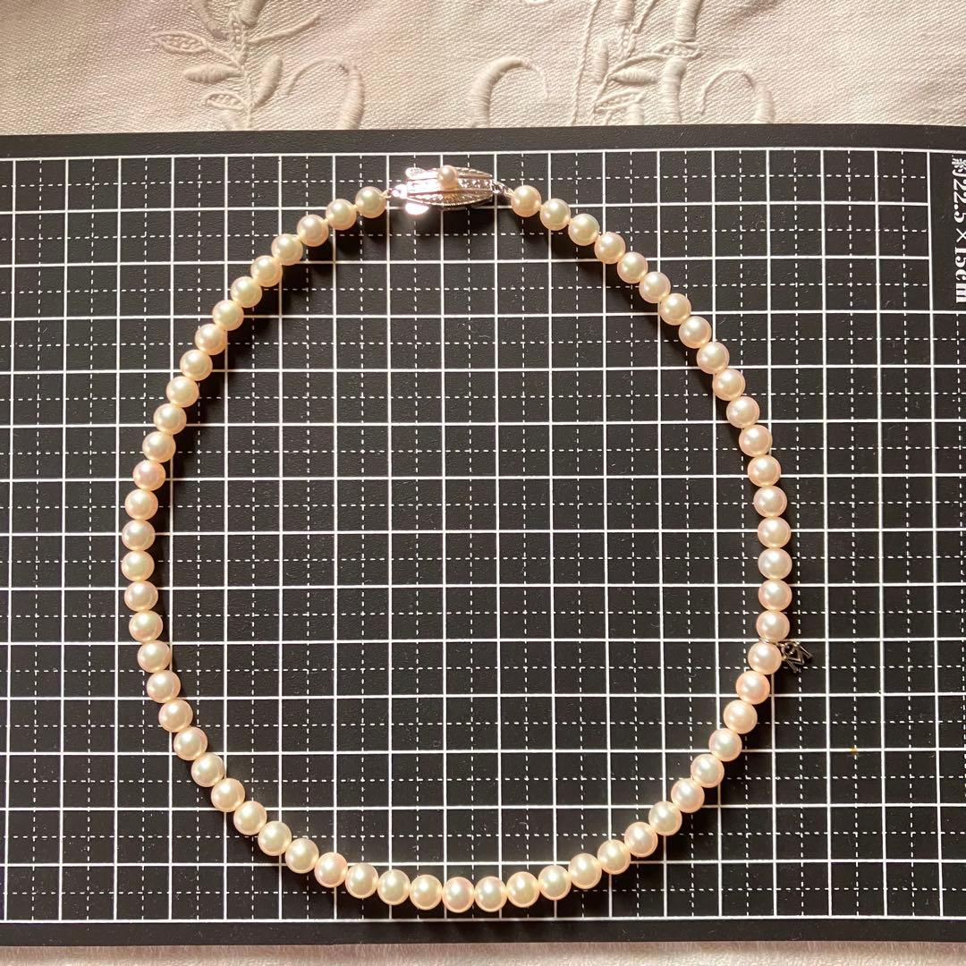 MIKIMOTO pearl choker necklace with 63 round pearls and silver M engraved clasp displayed with original box