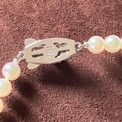 MIKIMOTO pearl choker necklace with 63 round pearls and silver M engraved clasp displayed with original box