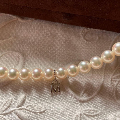 MIKIMOTO pearl choker necklace with 63 round pearls and silver M engraved clasp displayed with original box