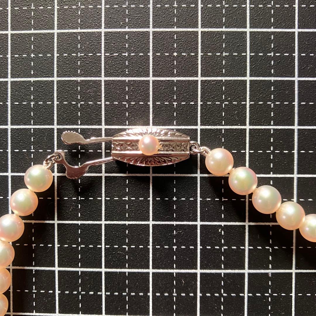 MIKIMOTO pearl choker necklace with 63 round pearls and silver M engraved clasp displayed with original box