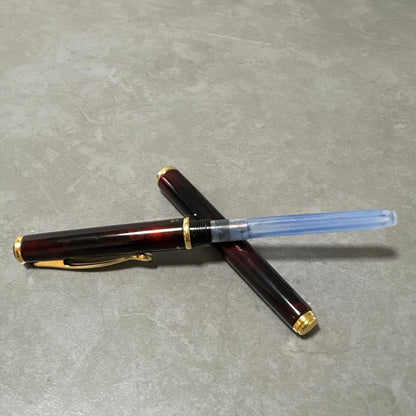 Pilot Cavalier fountain pen in dark brown with gold trim and capped nib on white background