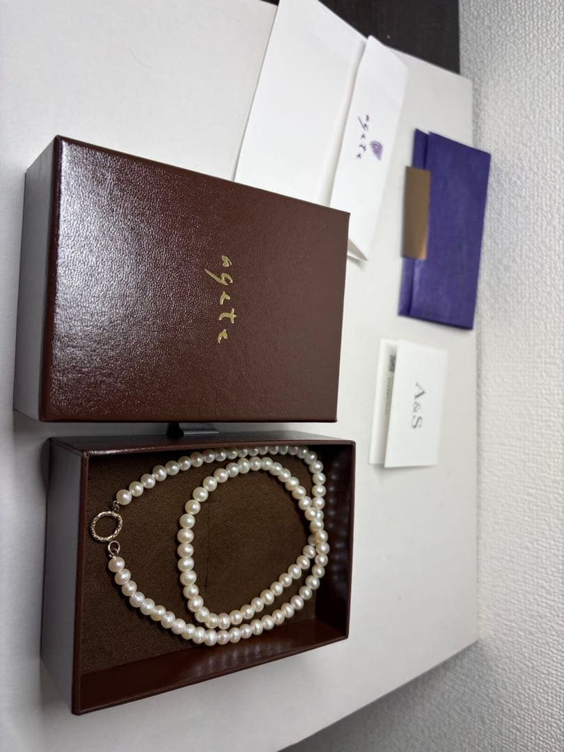 Agete pearl necklace featuring lustrous freshwater pearls displayed with gift box and guarantee card