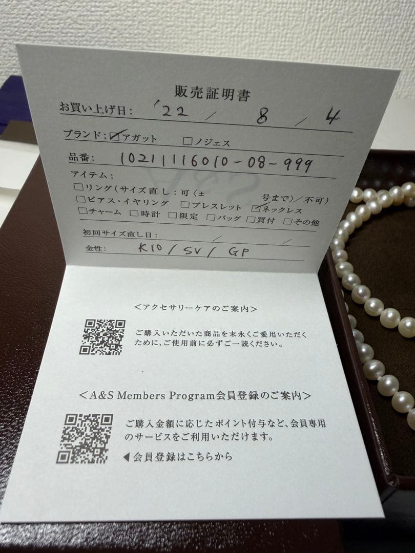 Agete pearl necklace featuring lustrous freshwater pearls displayed with gift box and guarantee card