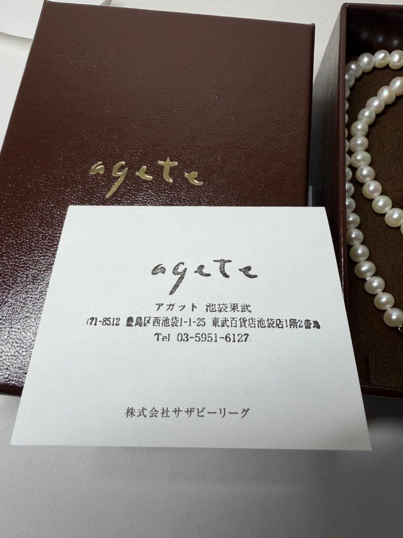 Agete pearl necklace featuring lustrous freshwater pearls displayed with gift box and guarantee card