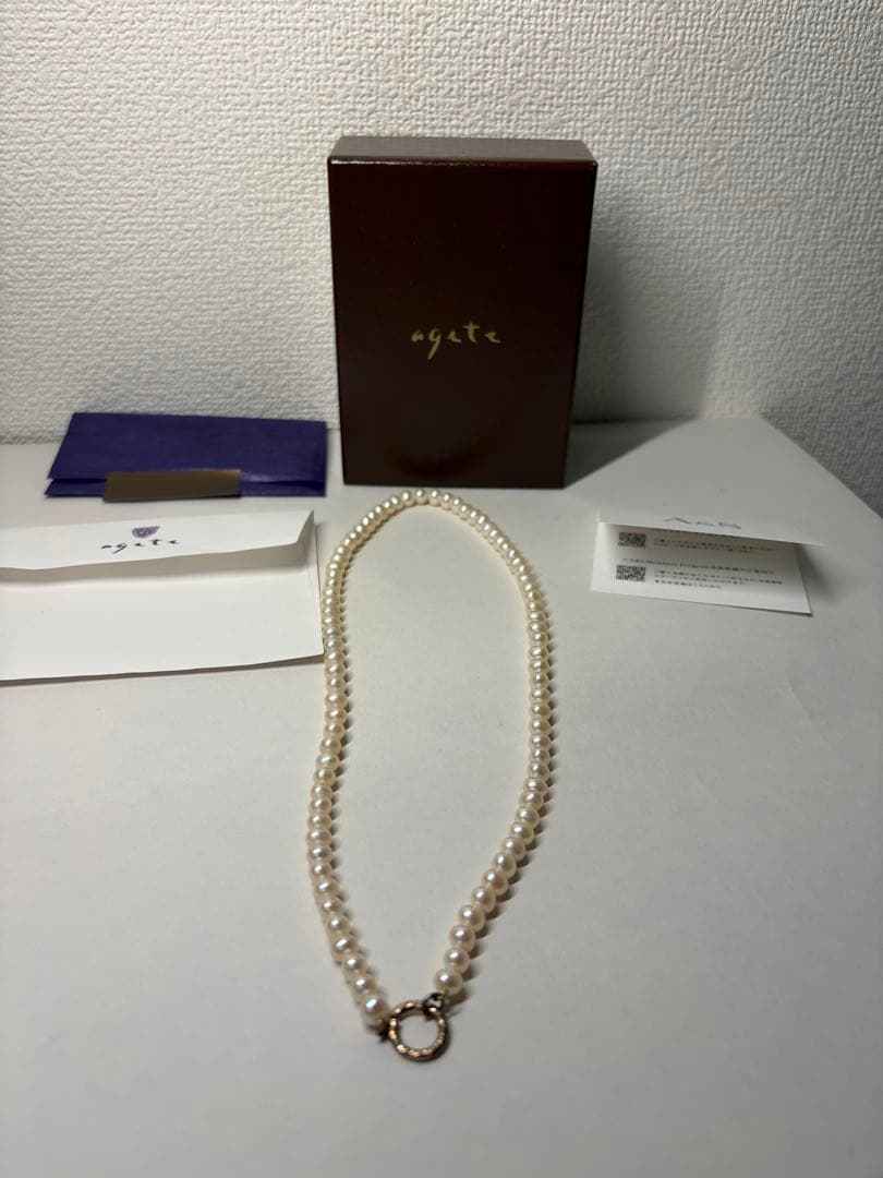 Agete pearl necklace featuring lustrous freshwater pearls displayed with gift box and guarantee card