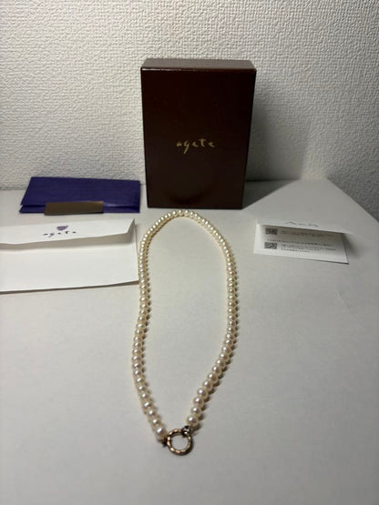 Agete pearl necklace featuring lustrous freshwater pearls displayed with gift box and guarantee card