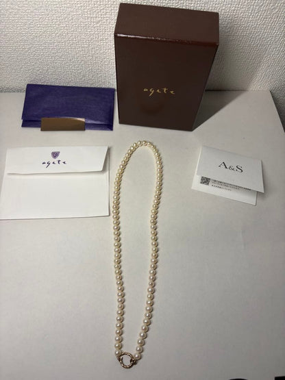 Agete pearl necklace featuring lustrous freshwater pearls displayed with gift box and guarantee card