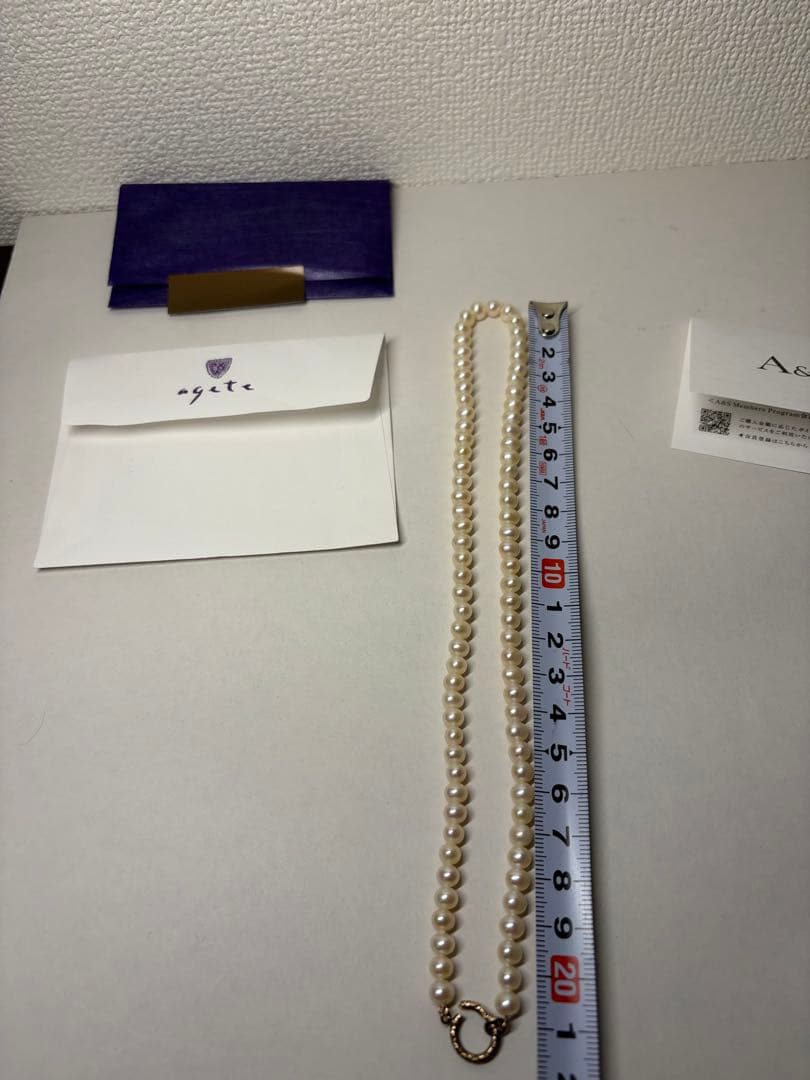 Agete pearl necklace featuring lustrous freshwater pearls displayed with gift box and guarantee card