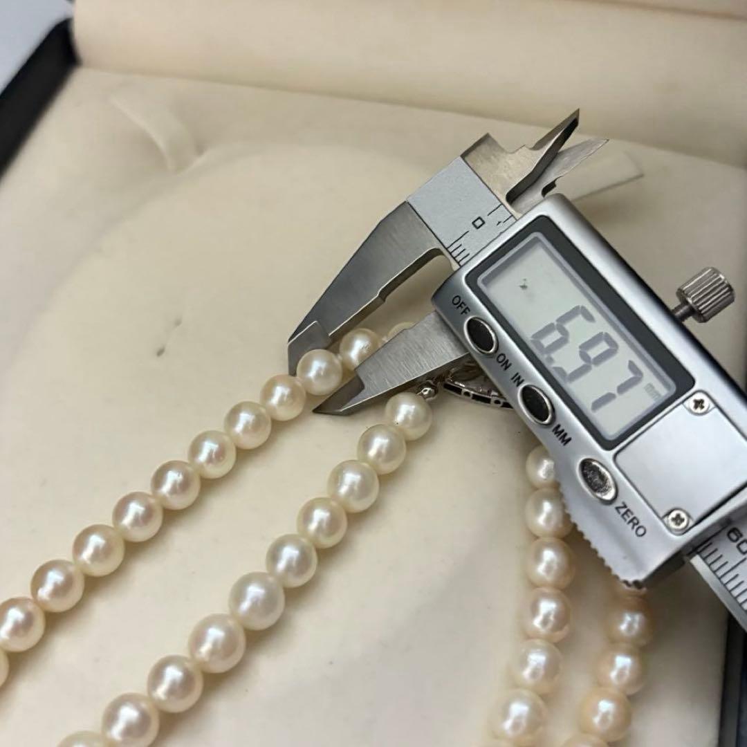 Two-strand long white Akoya pearl necklace with 7.5mm pearls on a white background