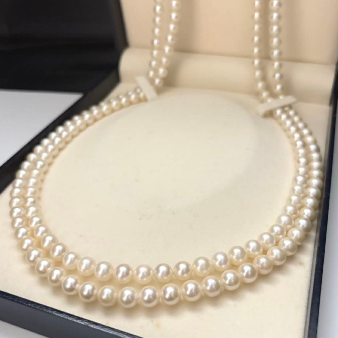 Two-strand long white Akoya pearl necklace with 7.5mm pearls on a white background