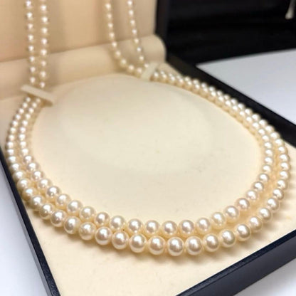 Two-strand long white Akoya pearl necklace with 7.5mm pearls on a white background