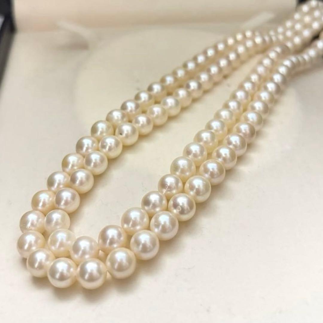 Two-strand long white Akoya pearl necklace with 7.5mm pearls on a white background