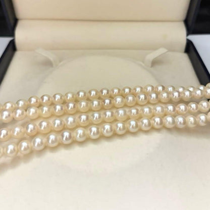 Two-strand long white Akoya pearl necklace with 7.5mm pearls on a white background