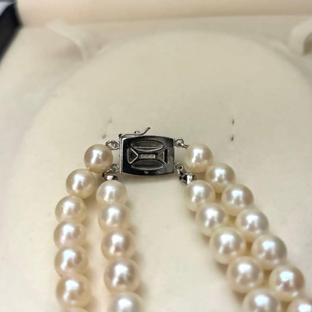 Two-strand long white Akoya pearl necklace with 7.5mm pearls on a white background