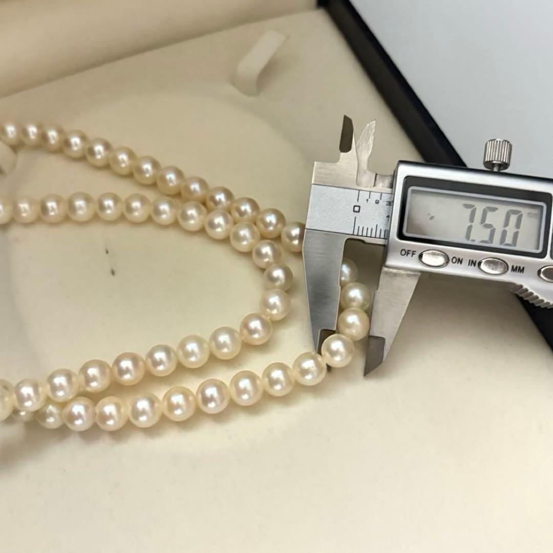 Two-strand long white Akoya pearl necklace with 7.5mm pearls on a white background