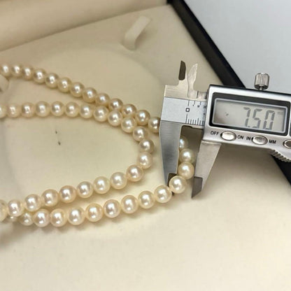 Two-strand long white Akoya pearl necklace with 7.5mm pearls on a white background