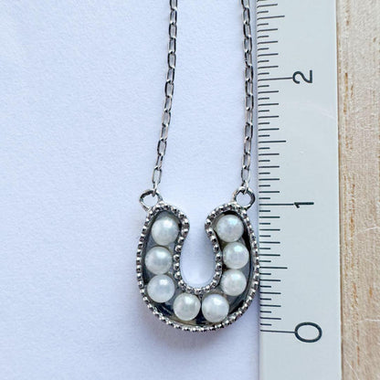 PT900 Akoya Pearl Horseshoe Pendant featuring 8 pearls on a PT850 chain with slide clasp