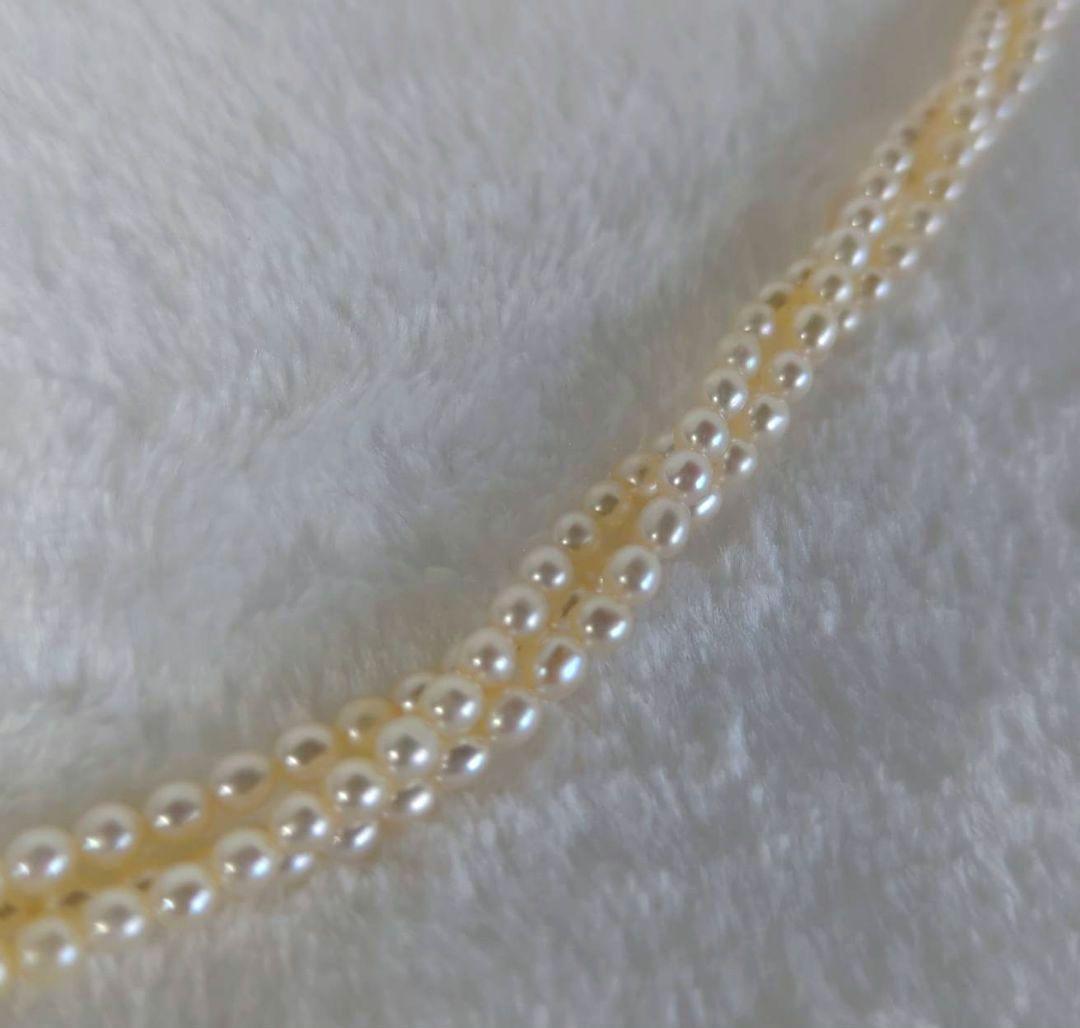 Tazaki Pearl 3-Strand necklace with baby freshwater pearls and silver case on white background