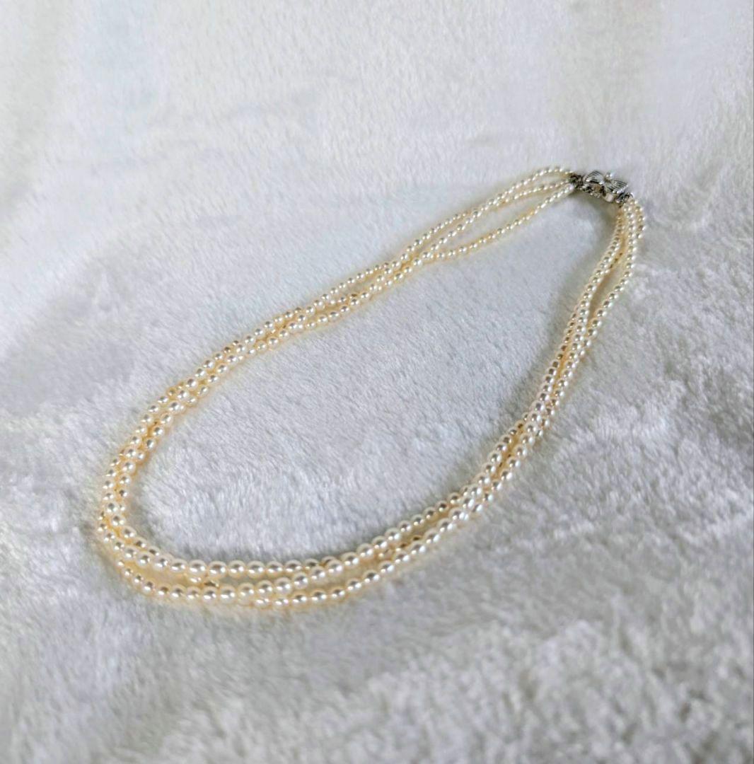Tazaki Pearl 3-Strand necklace with baby freshwater pearls and silver case on white background