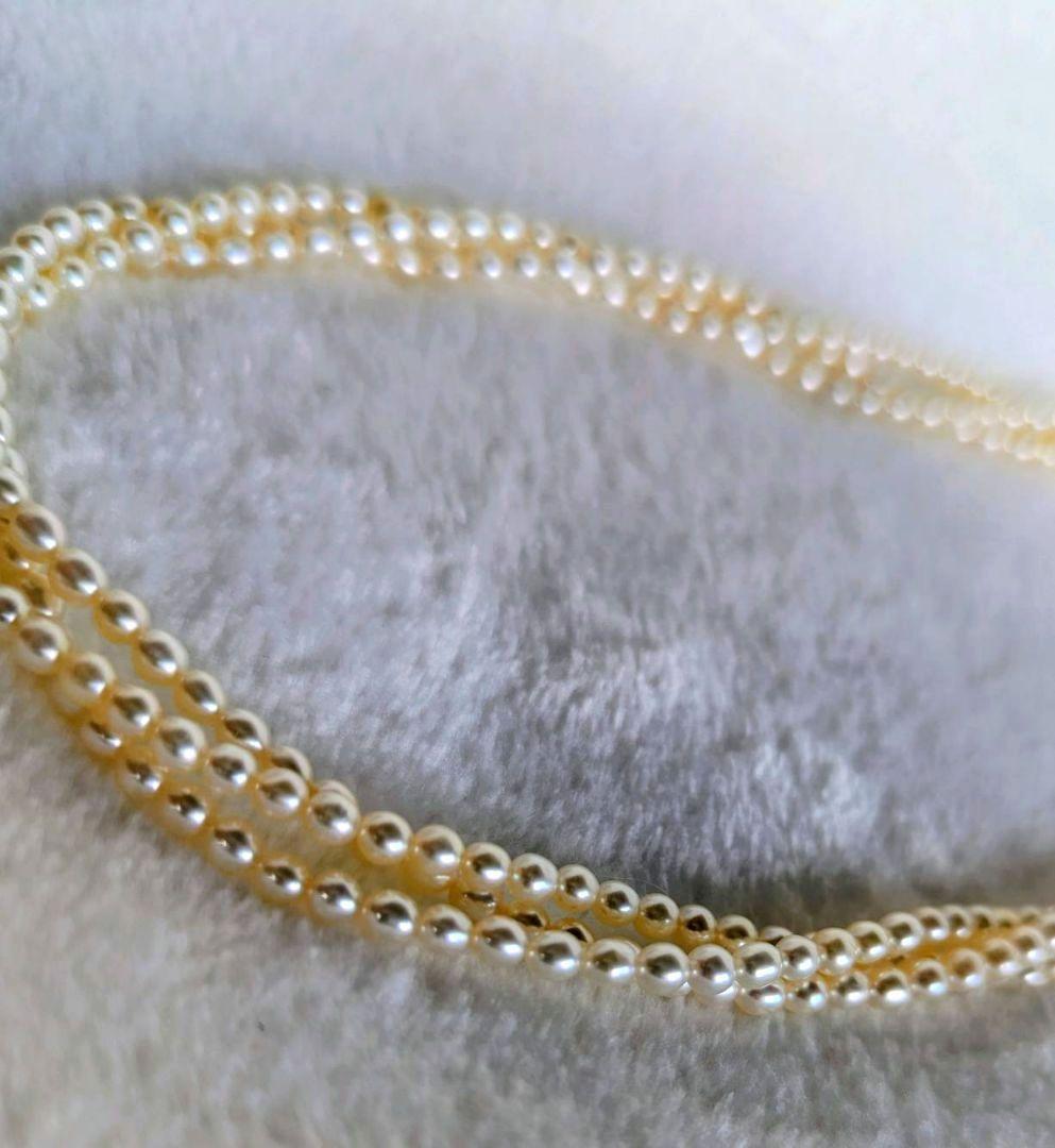 Tazaki Pearl 3-Strand necklace with baby freshwater pearls and silver case on white background