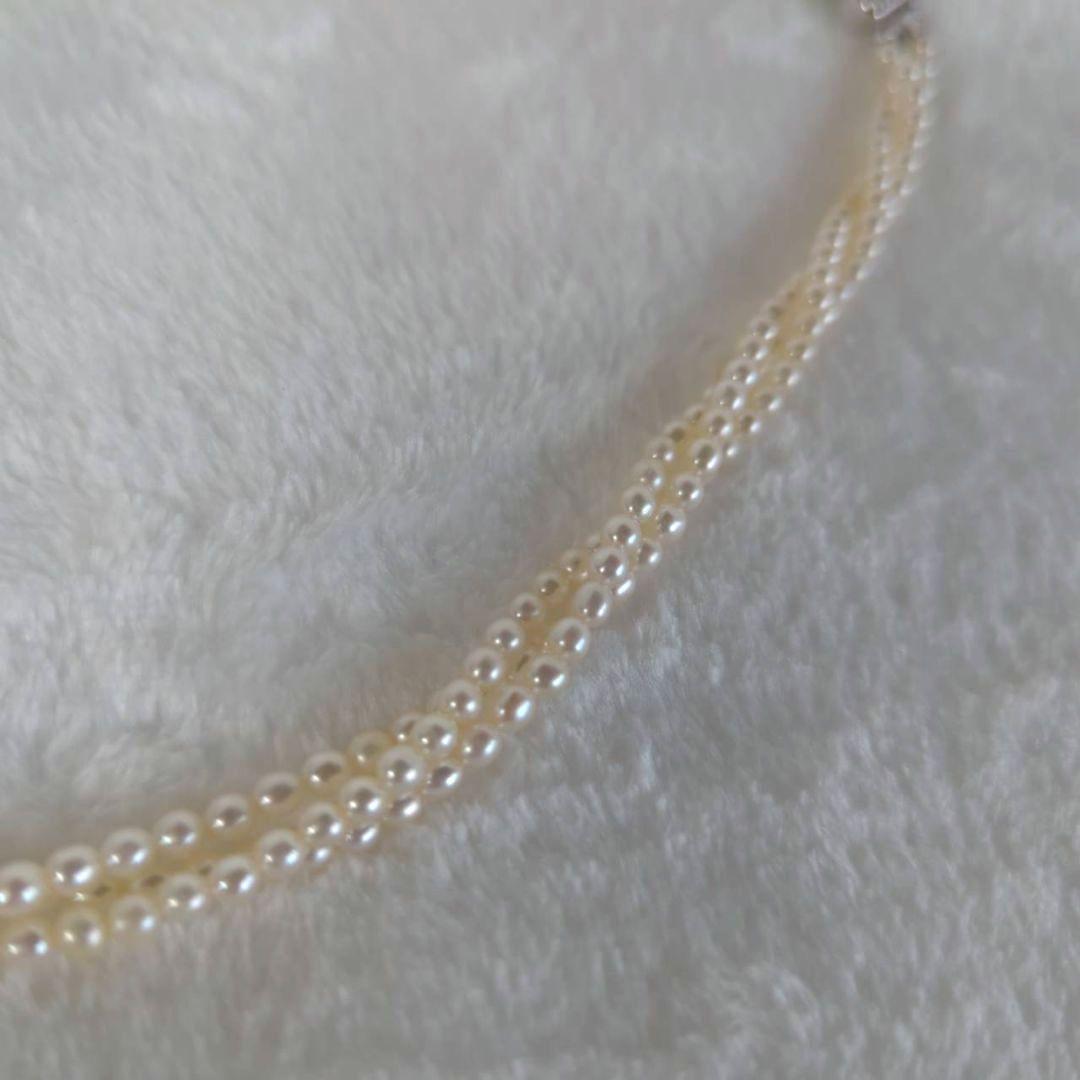 Tazaki Pearl 3-Strand necklace with baby freshwater pearls and silver case on white background