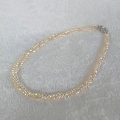 Tazaki Pearl 3-Strand necklace with baby freshwater pearls and silver case on white background