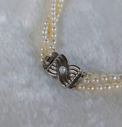 Tazaki Pearl 3-Strand necklace with baby freshwater pearls and silver case on white background