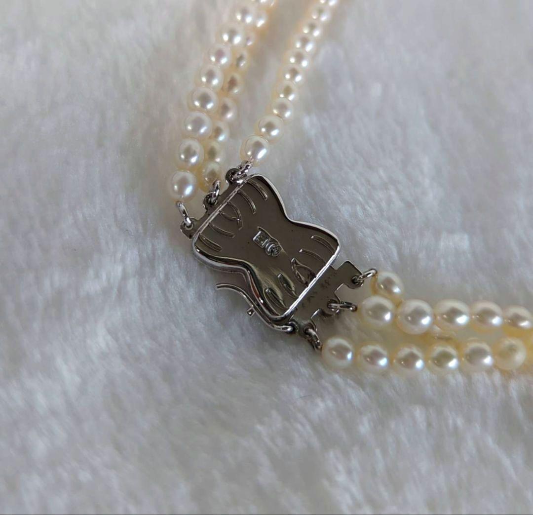 Tazaki Pearl 3-Strand necklace with baby freshwater pearls and silver case on white background