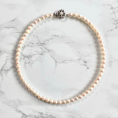Akoya pearl necklace with 6.5-7.0mm white pearls, silver clasp, 43.5cm length, showing pink and green shimmer colors