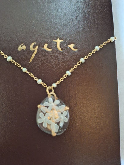 agete flower motif necklace with gold flower pendant and metal chain displayed with dedicated box