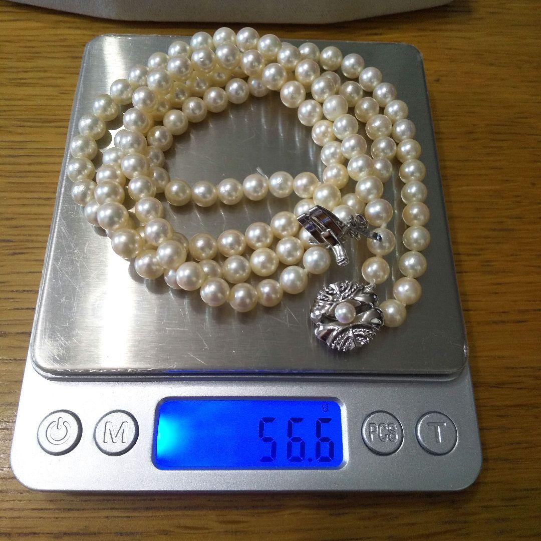 Authentic Akoya pearl double necklace with cream pearls and silver decorated clasp on white background