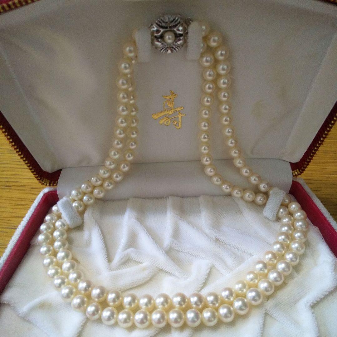 Authentic Akoya pearl double necklace with cream pearls and silver decorated clasp on white background