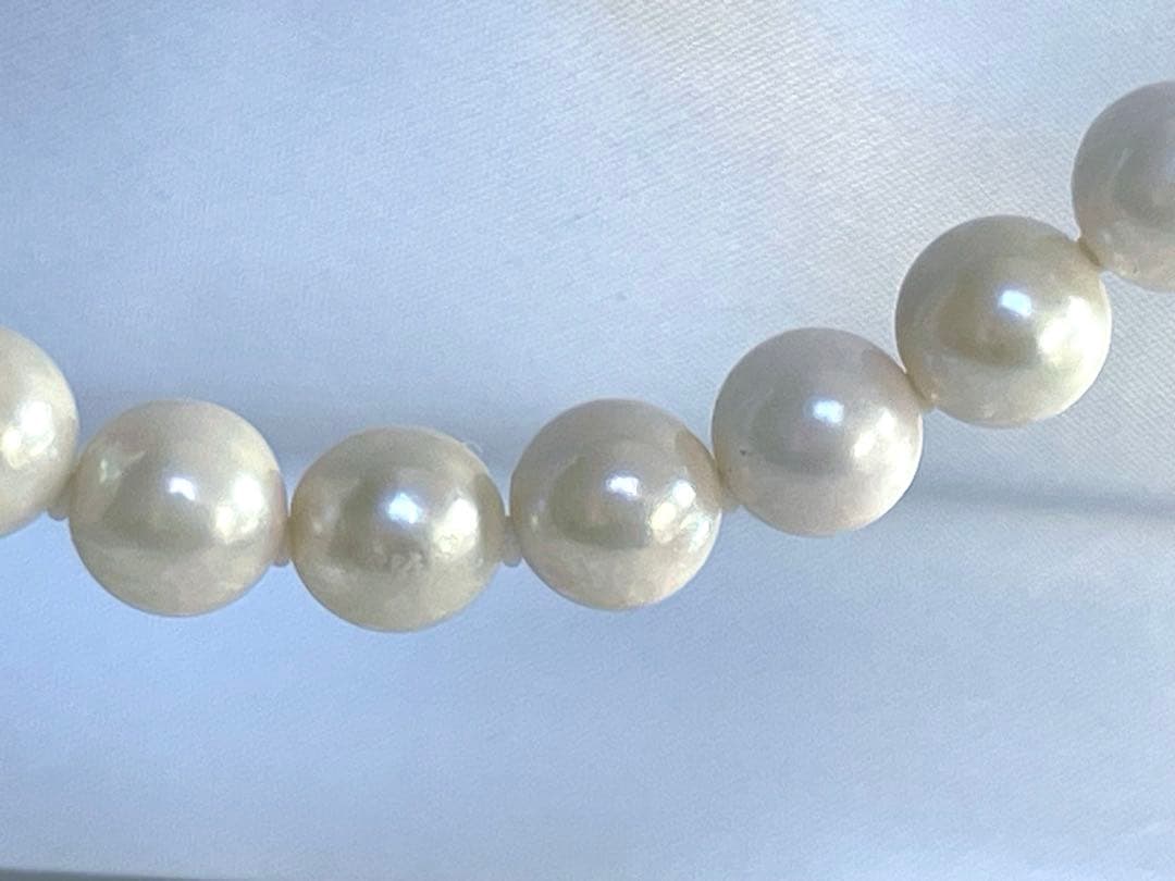 8.5mm Akoya pearl necklace with silver clasp and matching round pearl earrings featuring exposed flesh markings
