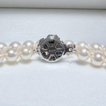 Akoya pearl necklace with white 6.5-6.9mm pearls and silver clasp on a white background
