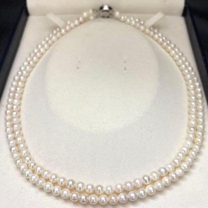 Two-strand necklace with white 5.5mm round Akoya baby pearls featuring silver mark