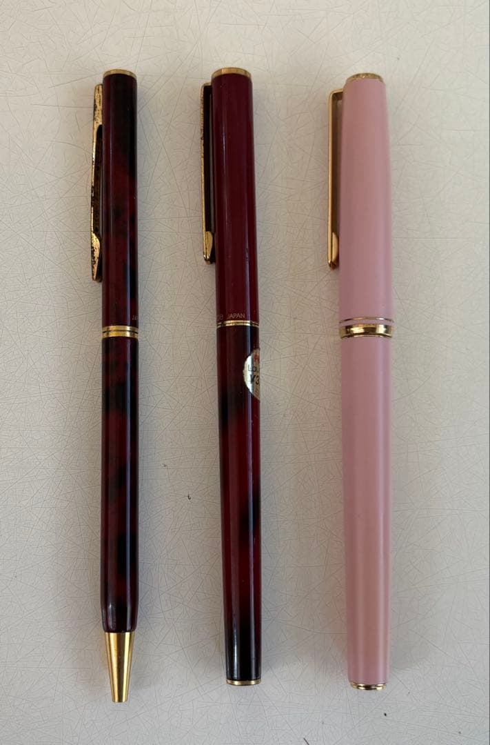 Set of 4 vintage PILOT Laureate ballpoint pens in pink, Bordeaux, and Bordeaux marble colors with visible aging