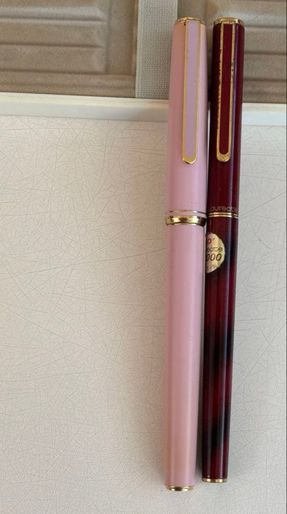 Set of 4 vintage PILOT Laureate ballpoint pens in pink, Bordeaux, and Bordeaux marble colors with visible aging