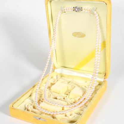 Akoya genuine pearl long necklace featuring two rows of flower pearl inclusions on a white background