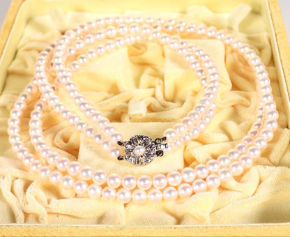 Akoya genuine pearl long necklace featuring two rows of flower pearl inclusions on a white background