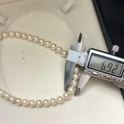 Long Akoya pearl necklace, 108cm length, 7mm pearls, 2-strand design, white pearls on a jewelry display